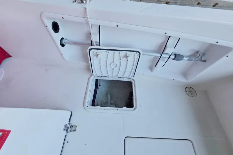 Slide: The Image of 2013 Atlas Boat Works Pompano 21 deck with open storage hatch and paddle. - 16