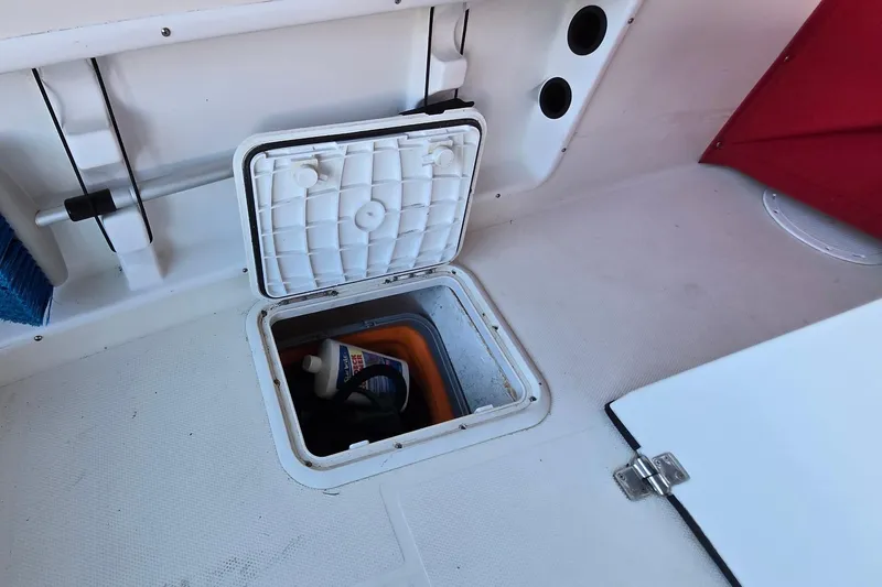 Slide: The Image of 2013 Atlas Boat Works Pompano 21 storage compartment with cleaning supplies. - 17