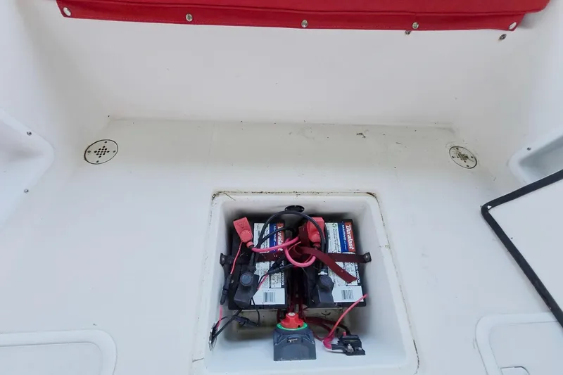 Slide: The Image of 2013 Atlas Boat Works Pompano 21 battery compartment with red cover and wiring. - 18