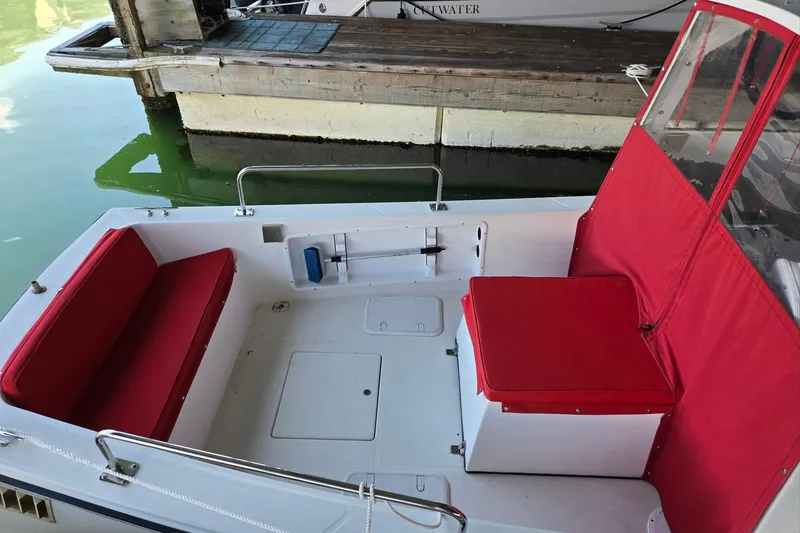 Slide: The Image of 2013 Atlas Boat Works Pompano 21 with red seating, docked by wooden pier. - 19