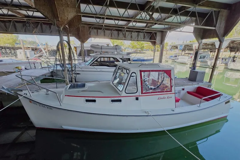 Slide: The Image of 2013 Atlas Boat Works Pompano 21 docked in a marina under a covered structure. - 2