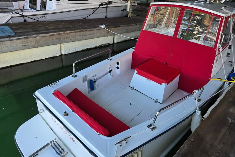 Slide: The Image of 2013 Atlas Boat Works Pompano 21 with red seating, docked in a marina. - 20