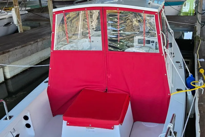 Slide: The Image of 2013 Atlas Boat Works Pompano 21 with red canopy docked in marina. - 21