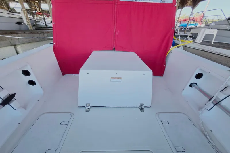 Slide: The Image of 2013 Atlas Boat Works Pompano 21 interior with red canopy and storage compartments. - 23