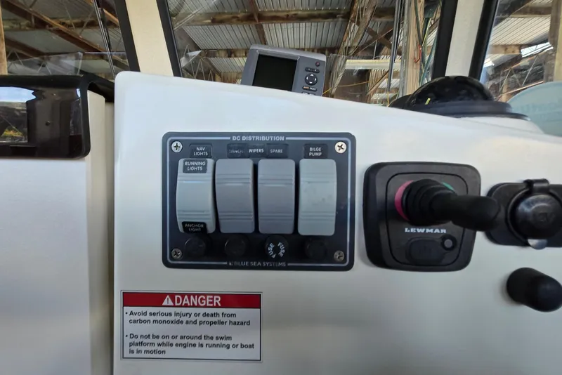 Slide: The Image of Control panel of a 2013 Atlas Boat Works Pompano 21 with switches and safety warning. - 41