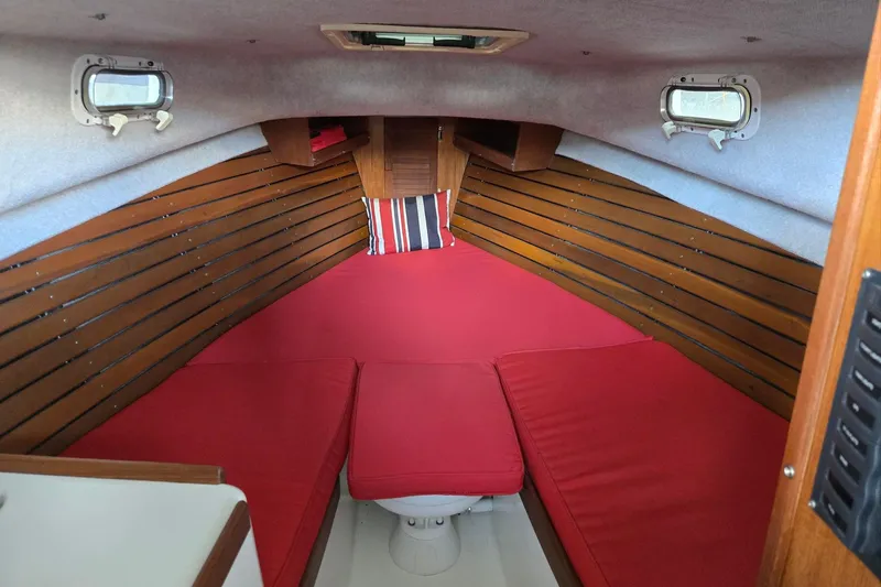 Slide: The Image of Interior of 2013 Atlas Boat Works Pompano 21 with red cushions and wooden paneling. - 43