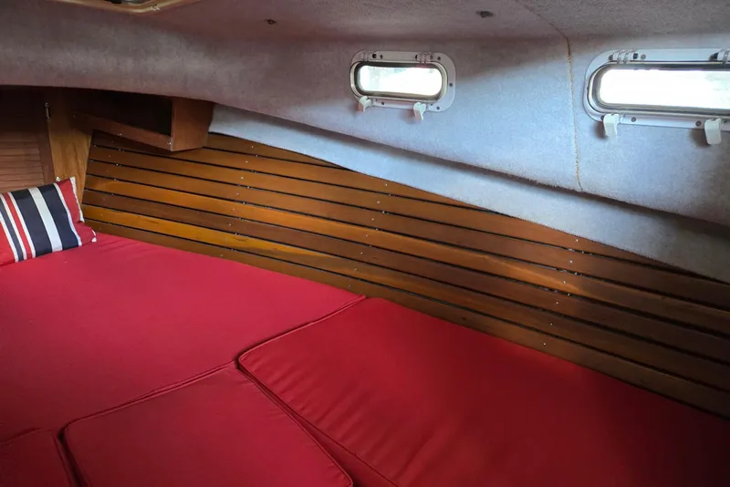 Slide: The Image of Interior cabin of 2013 Atlas Boat Works Pompano 21 with red cushions and striped pillow. - 44