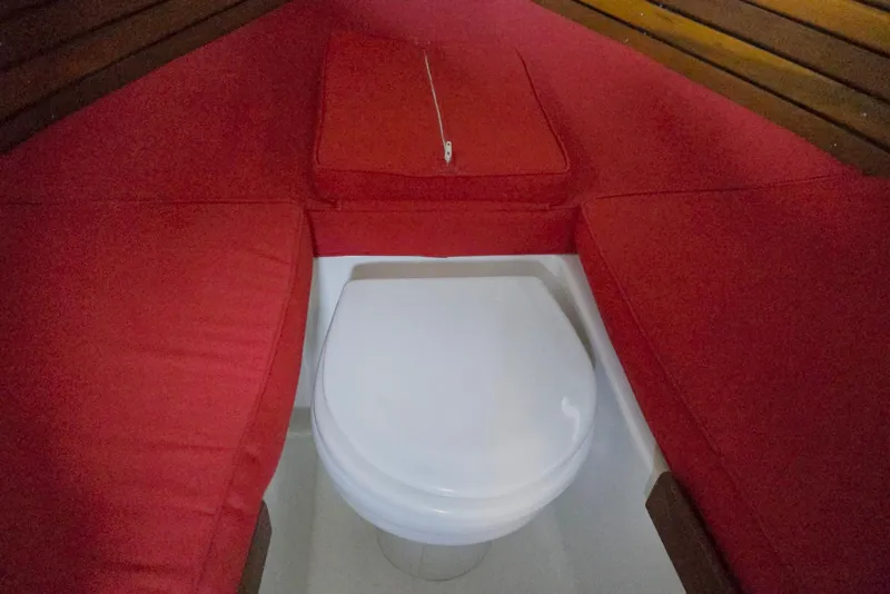 Slide: The Image of 2013 Atlas Boat Works Pompano 21 interior with red cushions and a white toilet. - 49