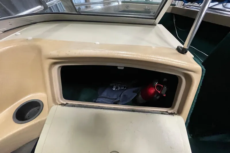 Slide: The Image of 1997 Lund 1700 Pro Sport boat storage compartment with red water bottle inside. - 18