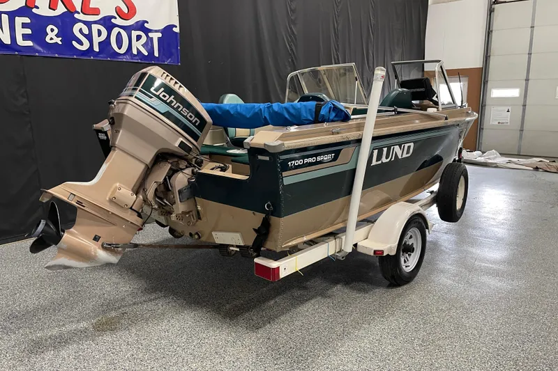 Slide: The Image of 1997 Lund 1700 Pro Sport boat with Johnson outboard motor on trailer in showroom. - 3