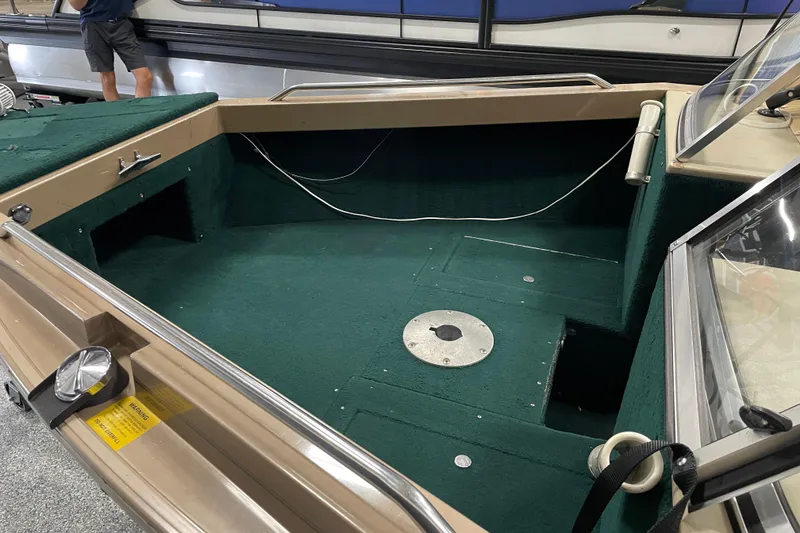 Slide: The Image of 1997 Lund 1700 Pro Sport boat interior with green carpet and seating area. - 5