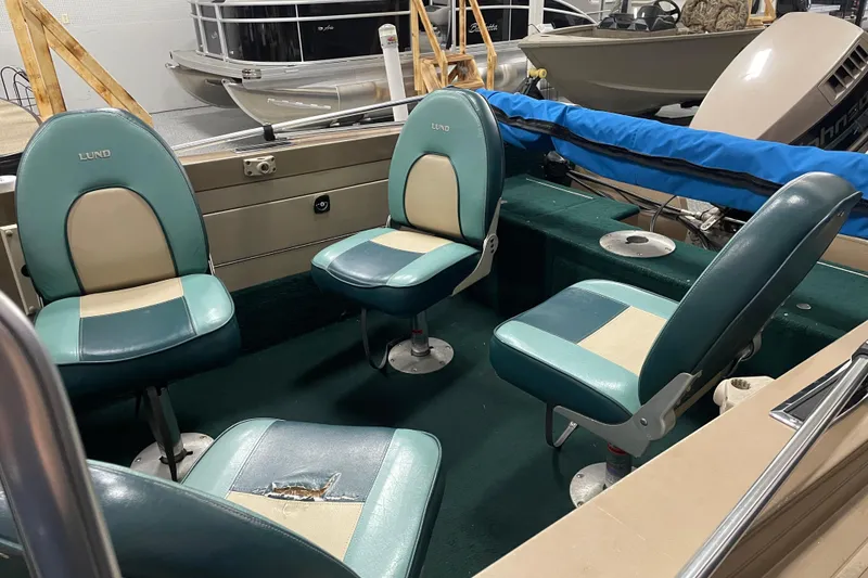 Slide: The Image of 1997 Lund 1700 Pro Sport boat interior with four teal and beige seats. - 6