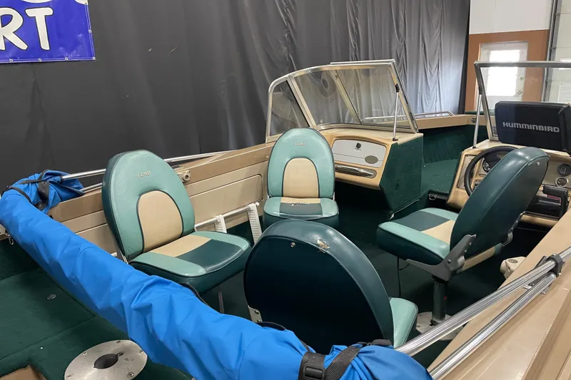Slide: The Image of 1997 Lund 1700 Pro Sport boat interior with green seats and Humminbird equipment. - 8