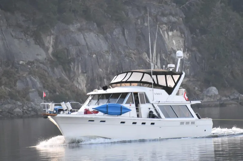 The Image of 1989 Bayliner 4588 Pilothouse cruising near rocky shoreline. - 0