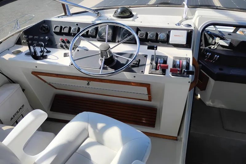 Slide: The Image of 1989 Bayliner 4588 Pilothouse helm with steering wheel and control panel. - 11
