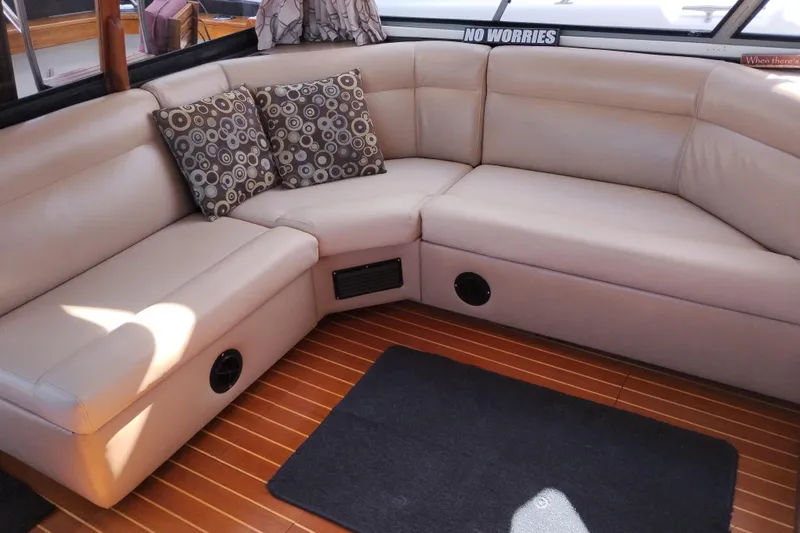 Slide: The Image of 1989 Bayliner 4588 Pilothouse interior with beige leather seating and patterned cushions. - 26