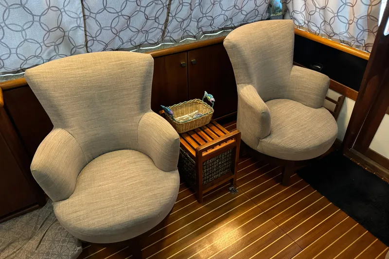 Slide: The Image of Interior of 1989 Bayliner 4588 Pilothouse Motor Yacht with two armchairs and wooden flooring. - 27