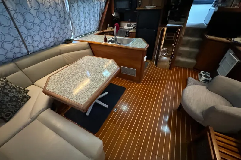 Slide: The Image of Interior of 1989 Bayliner 4588 Pilothouse Motor Yacht with elegant seating and wooden flooring. - 28