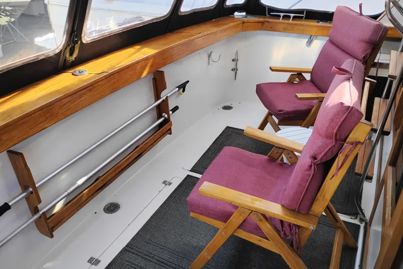 Slide: The Image of 1989 Bayliner 4588 Pilothouse interior with wooden chairs and purple cushions. - 3