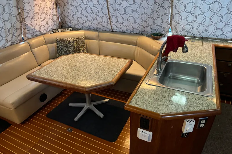Slide: The Image of 1989 Bayliner 4588 Pilothouse Motor Yacht interior with dining area and kitchenette. - 30
