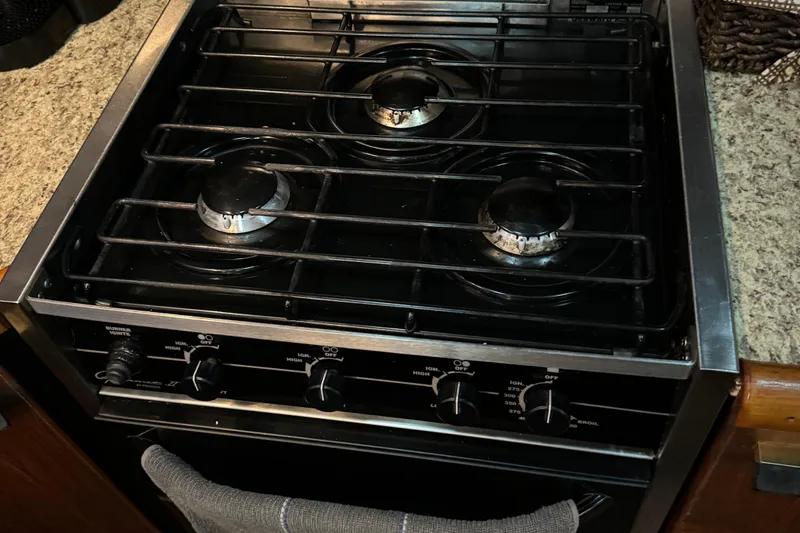 Slide: The Image of Stove with three burners on 1989 Bayliner 4588 Pilothouse Motor Yacht kitchen counter. - 33