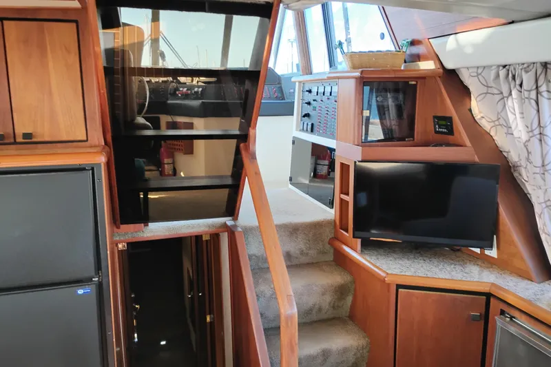 Slide: The Image of Interior of 1989 Bayliner 4588 Pilothouse with stairs, TV, and wooden cabinetry. - 36