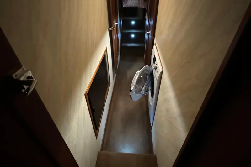 Slide: The Image of Narrow hallway inside 1989 Bayliner 4588 Pilothouse Motor Yacht with washing machine. - 37