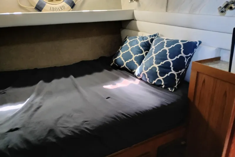 Slide: The Image of Cozy cabin interior of 1989 Bayliner 4588 Pilothouse with bed and decorative pillows. - 38