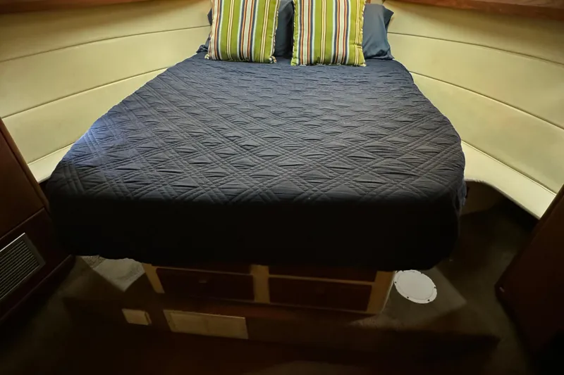 Slide: The Image of 1989 Bayliner 4588 Pilothouse Motor Yacht cabin with bed and striped pillows. - 44