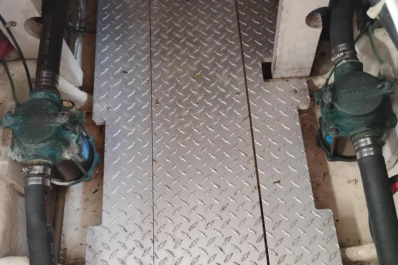 Slide: The Image of Engine room of 1989 Bayliner 4588 Pilothouse with metal flooring and hoses. - 50