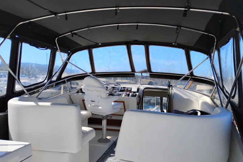 Slide: The Image of Interior view of 1989 Bayliner 4588 Pilothouse yacht with white seating and helm. - 8