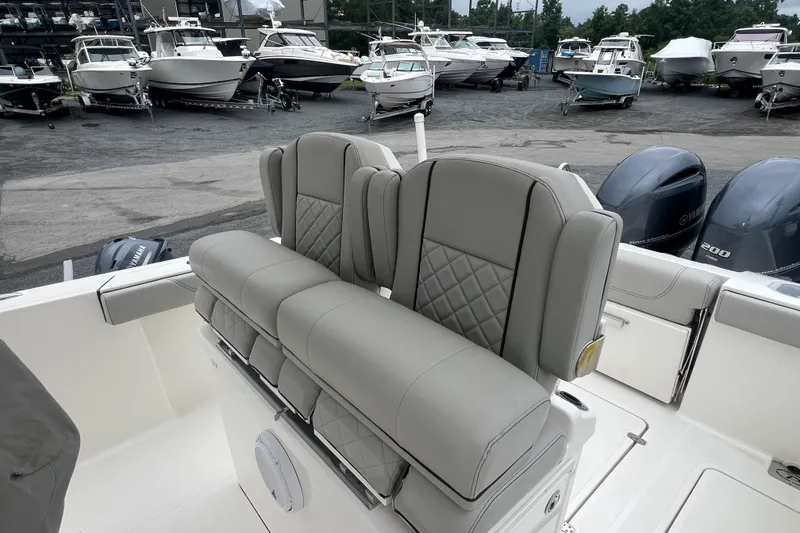 Slide: The Image of 2023 Pursuit S 268 Sport boat with luxurious seating, docked among other boats. - 14