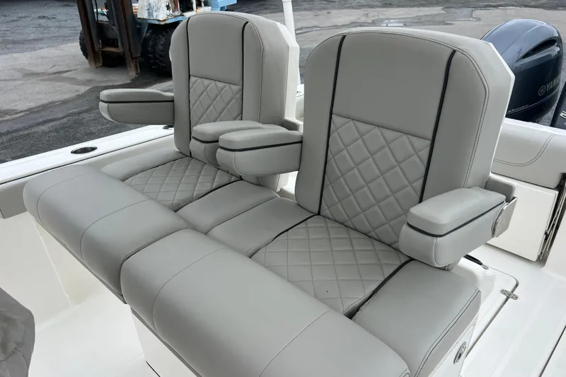 Slide: The Image of 2023 Pursuit S 268 Sport boat seats with diamond-stitched gray upholstery and armrests. - 15