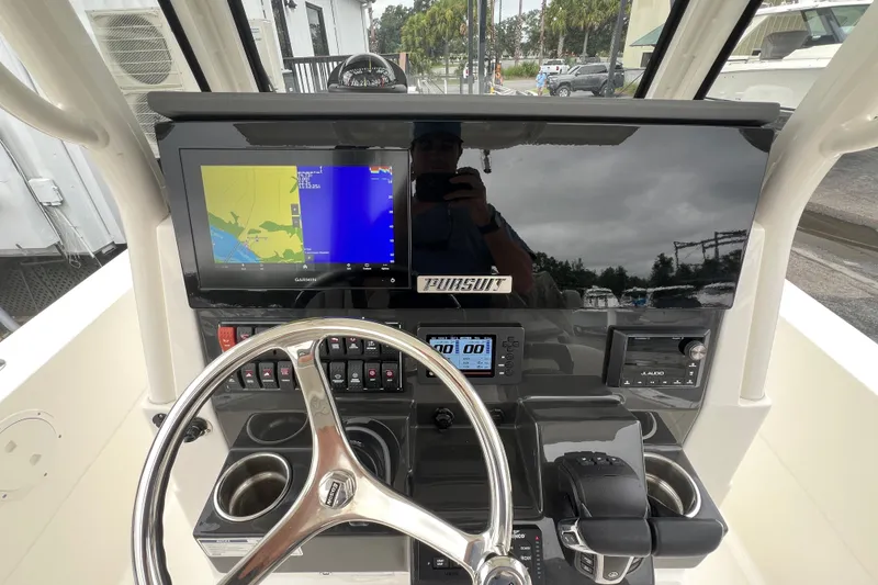 Slide: The Image of 2023 Pursuit S 268 Sport boat dashboard with navigation display and controls. - 16