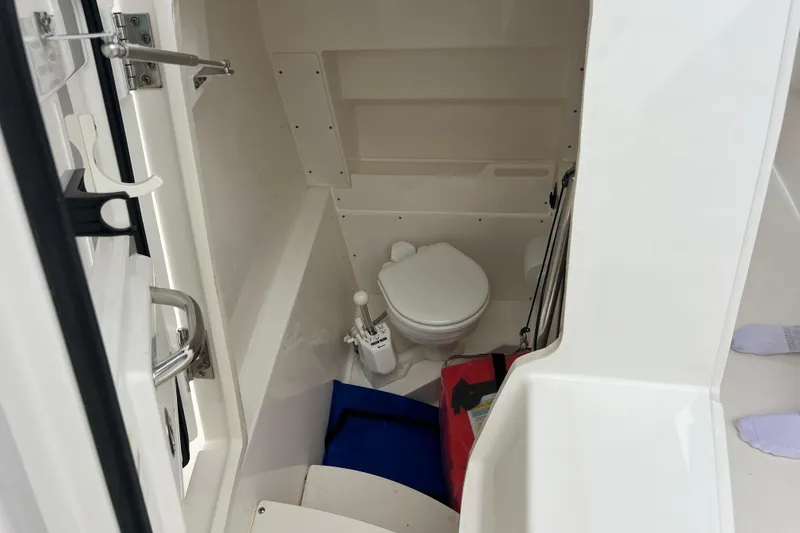 Slide: The Image of 2023 Pursuit S 268 Sport boat interior with compact marine toilet. - 20