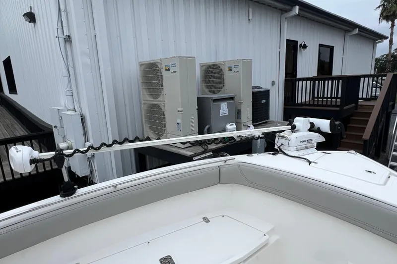 Slide: The Image of 2023 Pursuit S 268 Sport boat with mounted trolling motor near building. - 21