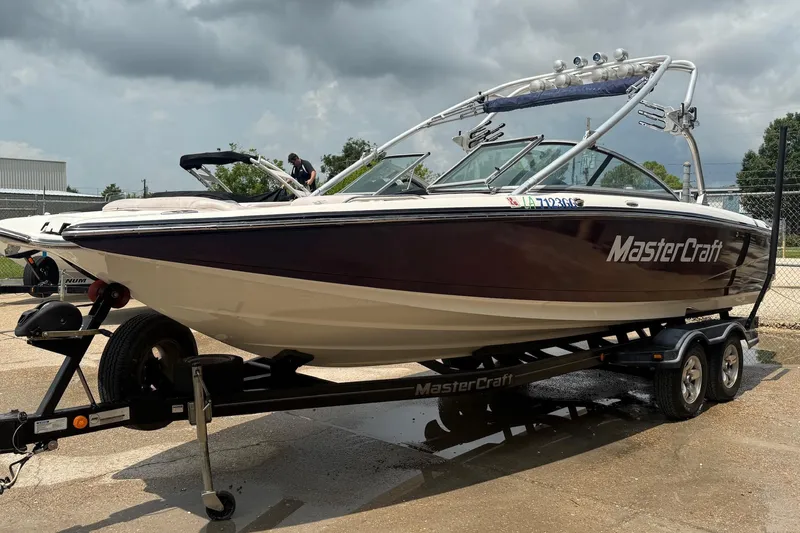 The Image of 2006 MasterCraft X45 boat on trailer, parked outdoors under cloudy sky. - 0