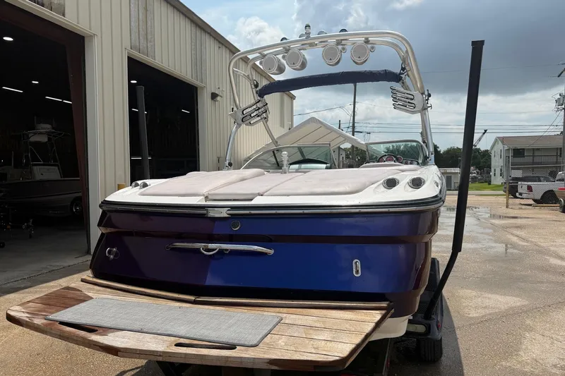Slide: The Image of 2006 MasterCraft X45 boat with blue hull, parked outside a warehouse. - 4