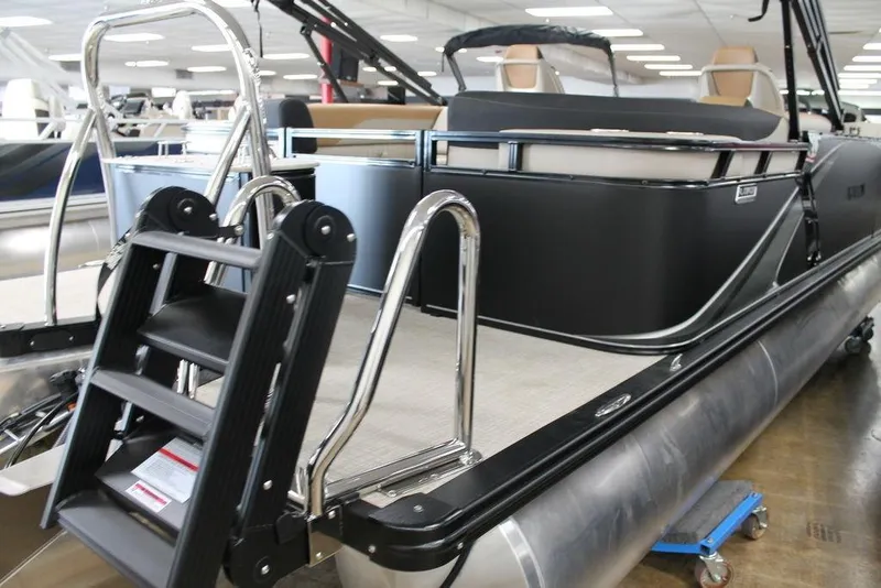 Slide: The Image of 2025 Avalon LSZ Quad Lounger 23 FT pontoon boat with sleek black design and ladder. - 4
