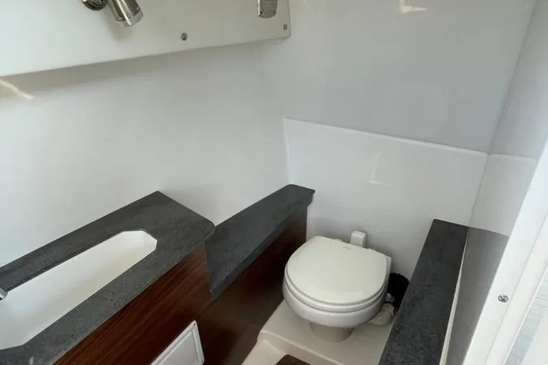 Slide: The Image of 2025 Four Winns H9 boat interior bathroom with modern fixtures and compact design. - 9