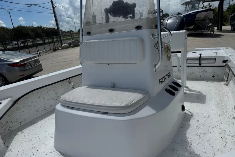 Slide: The Image of Frontier 2104 boat interior, 2011 model, featuring a central console and seating. - 10