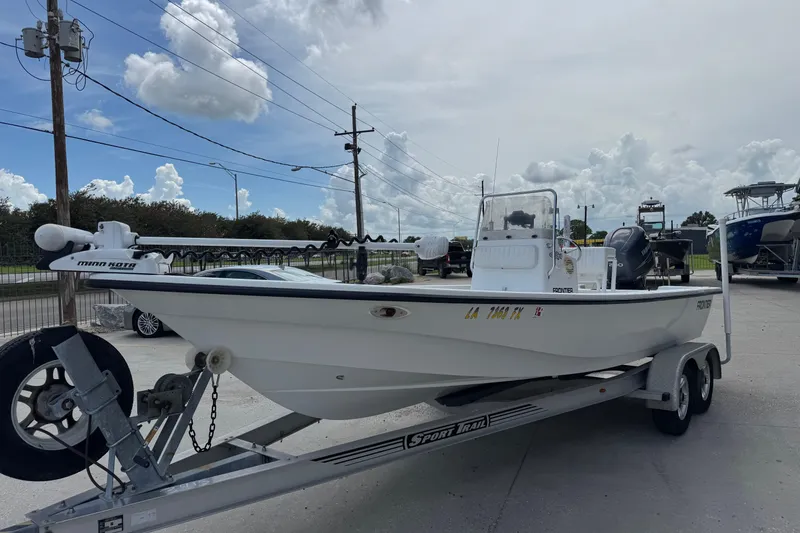 Slide: The Image of 2011 Frontier 2104 boat on trailer, parked outdoors under a cloudy sky. - 5
