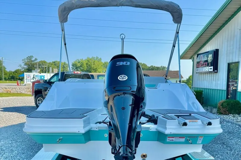Slide: The Image of 2026 Hurricane SS185-OB boat with outboard motor, parked outdoors near a building. - 2