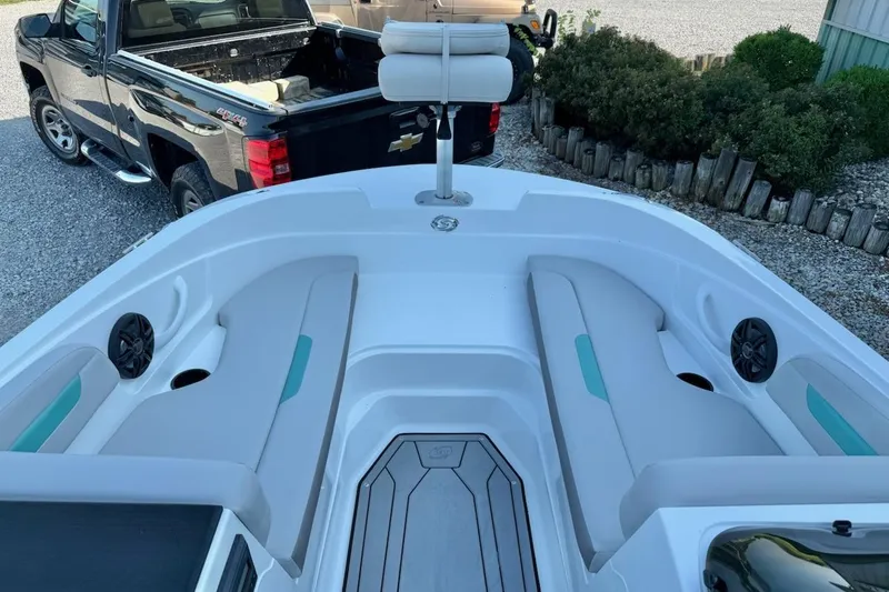 Slide: The Image of 2026 Hurricane SS185-OB boat interior with seating, speakers, and a pickup truck in the background. - 6