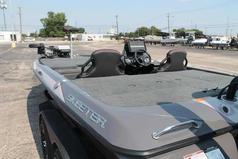 Slide: The Image of 2025 Skeeter ZXR21 boat with dual seats and advanced dashboard in a parking lot. - 2