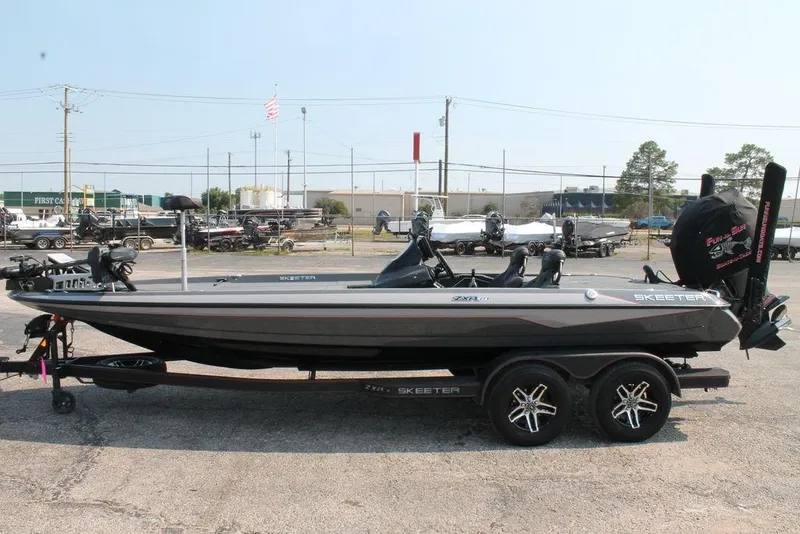 Slide: The Image of 2025 Skeeter ZXR21 bass boat on trailer in outdoor lot. - 6