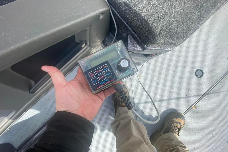 Slide: The Image of Hand holding a control device on a 2017 Ranger 621FS Fisherman boat deck. - 14