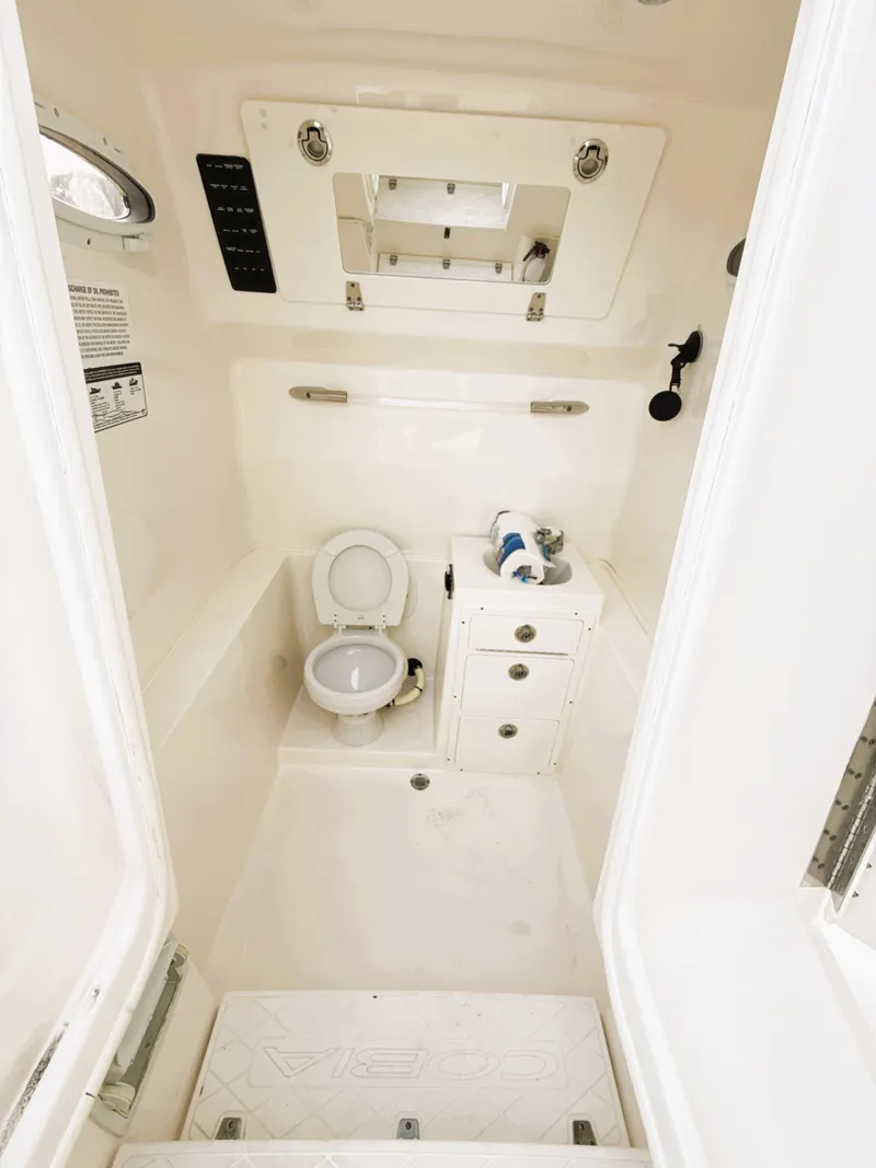 Slide: The Image of 2016 Cobia 296 Center Console boat interior with toilet and storage cabinet. - 15
