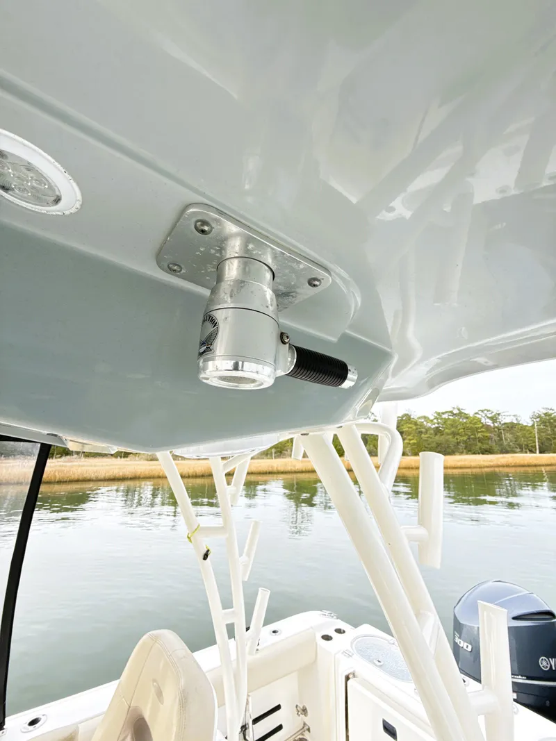 Slide: The Image of 2016 Cobia 296 Center Console boat detail with rod holders and water view. - 19