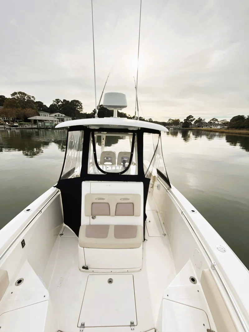 Slide: The Image of 2016 Cobia 296 Center Console boat on calm water, featuring spacious deck and seating. - 24